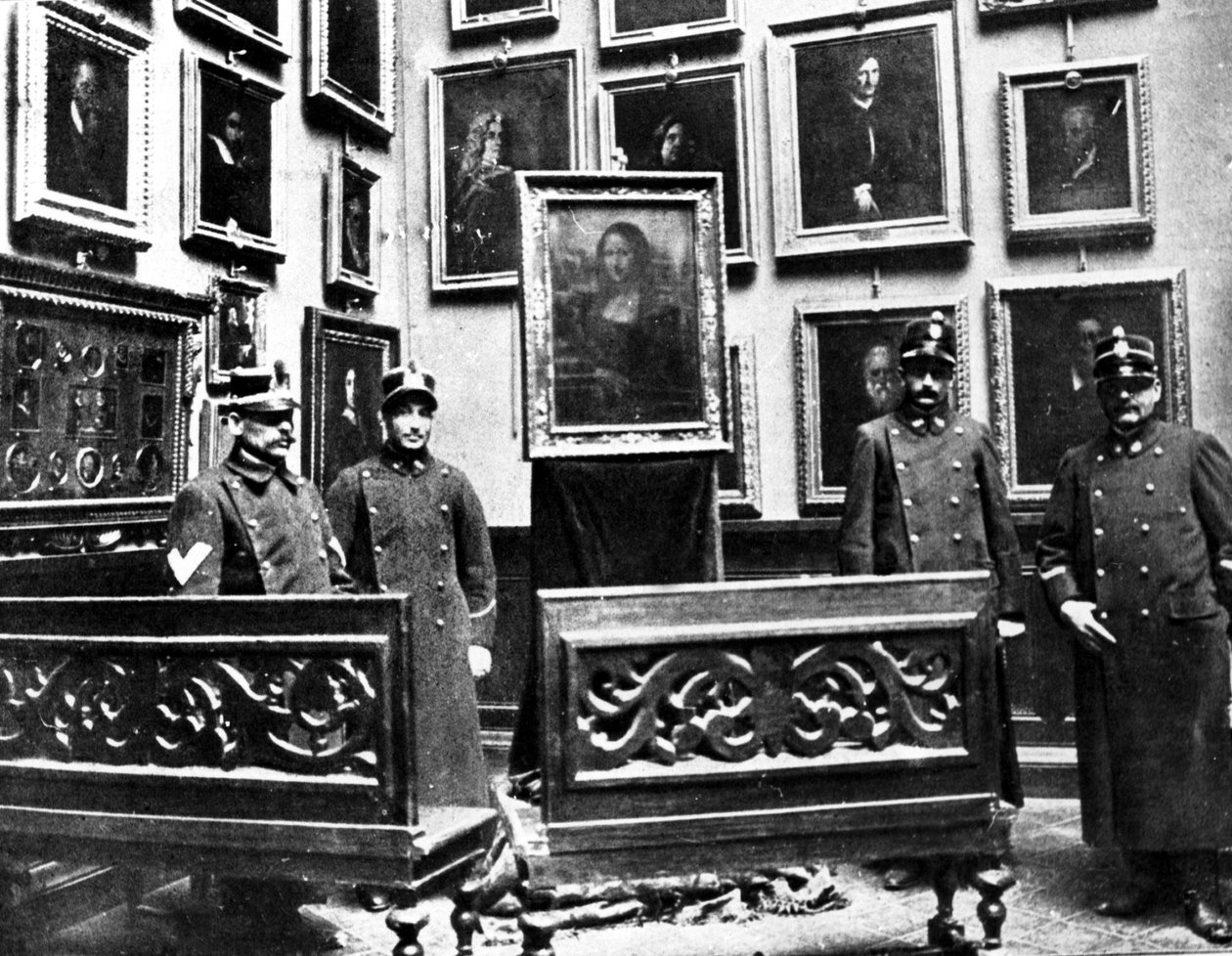 A Mona Lisa őrökkel a firenzei Uffizi múzeumban, a festményt éppen a Louvre-i múzeumban való ellopása után találta meg Vincenzo Peruggia olasz festő 1911. augusztus 21-én. alkotó: Unknown