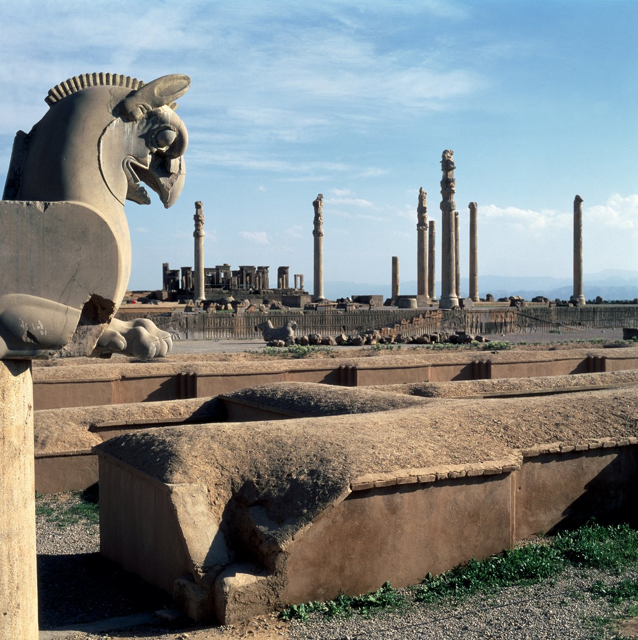 Kilátás az Apadana északi karzatára a Tacharával a háttérben, a Sapahan Spoy (Katona út) bejáratától alkotó: Achaemenid