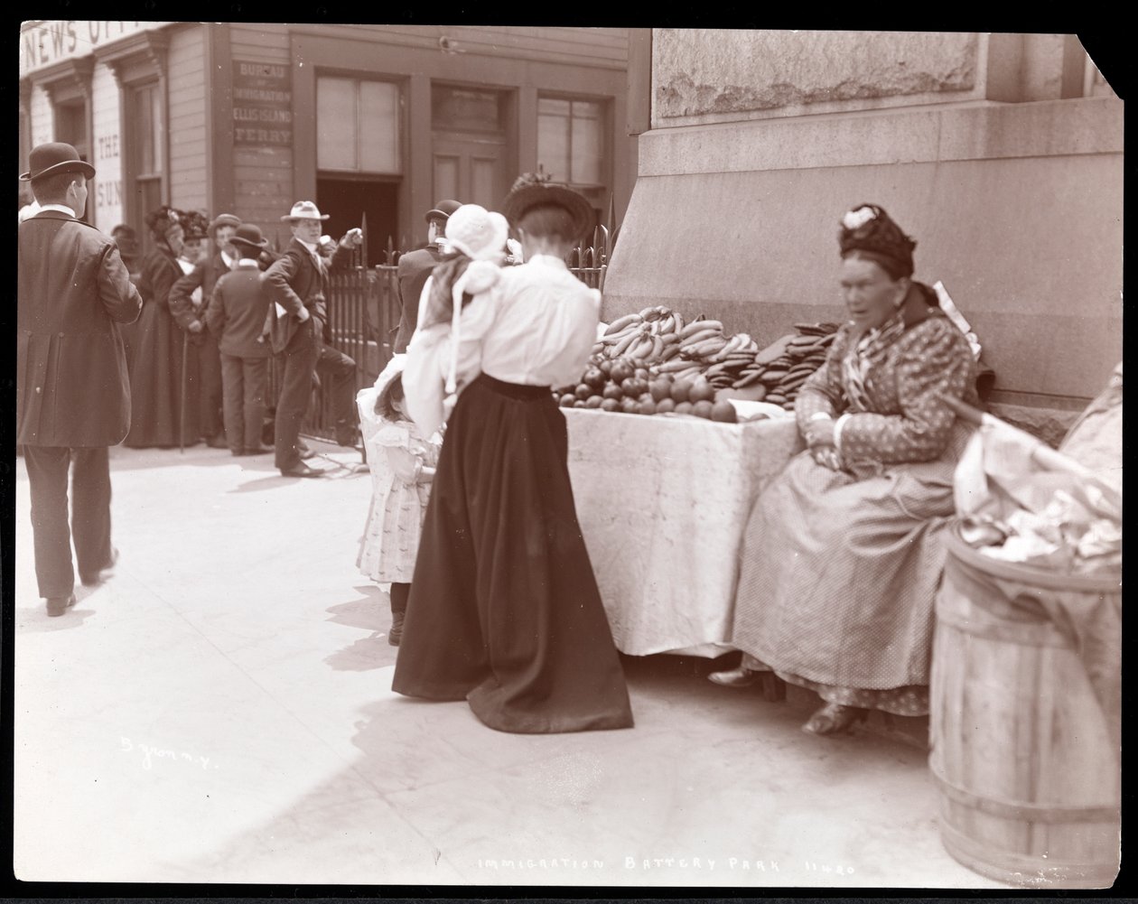 Látkép egy gyümölcsárusról a Battery Parkban, aki feltehetően a New York-i Ellis Islandről érkező bevándorlókat várja, 1901 körül (ezüstzselatinos nyomat). alkotó: Byron Company