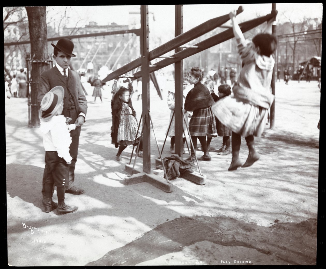 A Tompkins Square Park játszótéri eszközein játszó gyerekeket felügyelő férfi a Fenyő Napján, New York, 1904 (ezüstzselatinos nyomat) alkotó: Byron Company