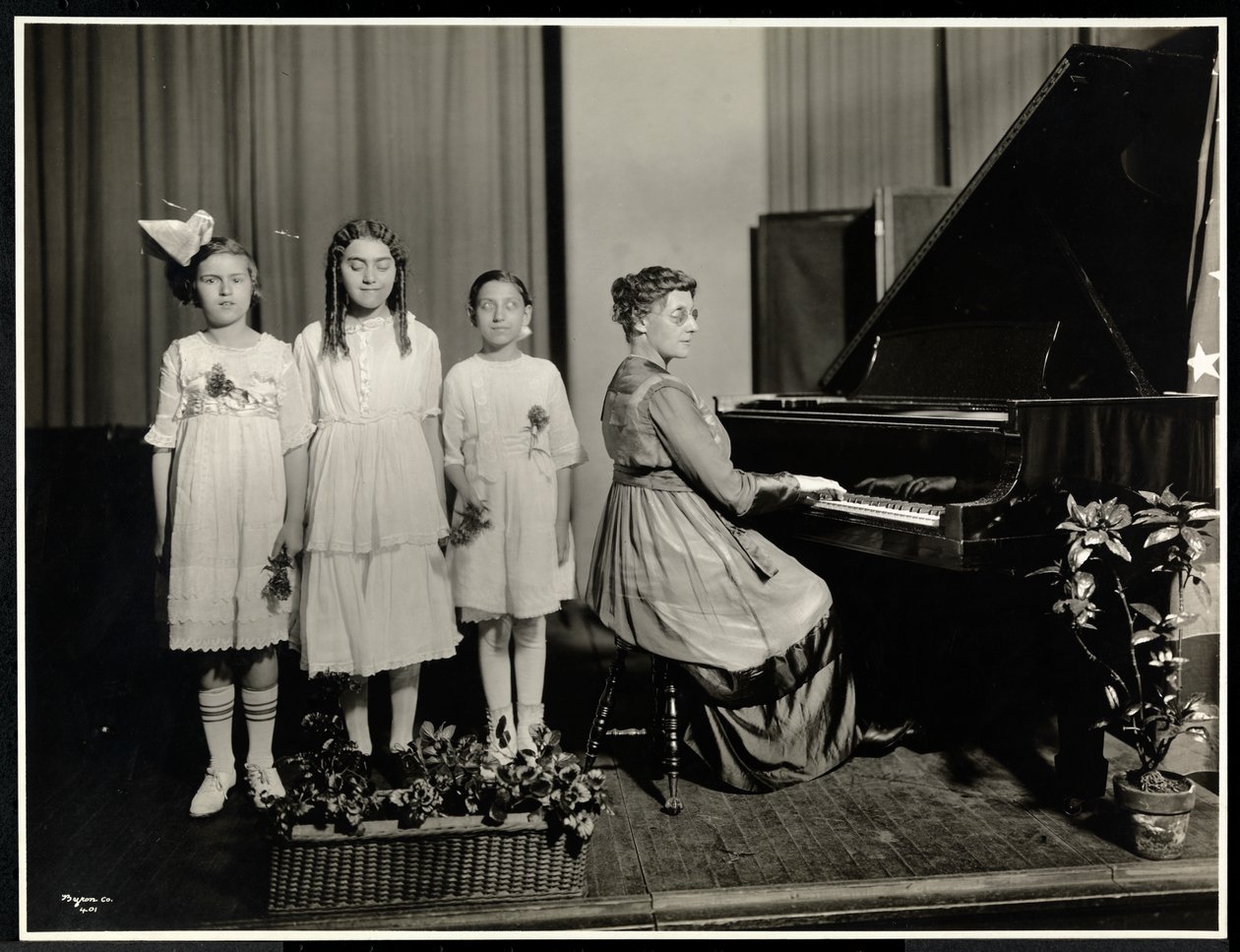 Nő zongorázik, miközben három lány énekel a New York-i Vakok Egyesületében, 111 East 59th Street, New York, 1917 körül (ezüstzselatinos nyomat) alkotó: Byron Company
