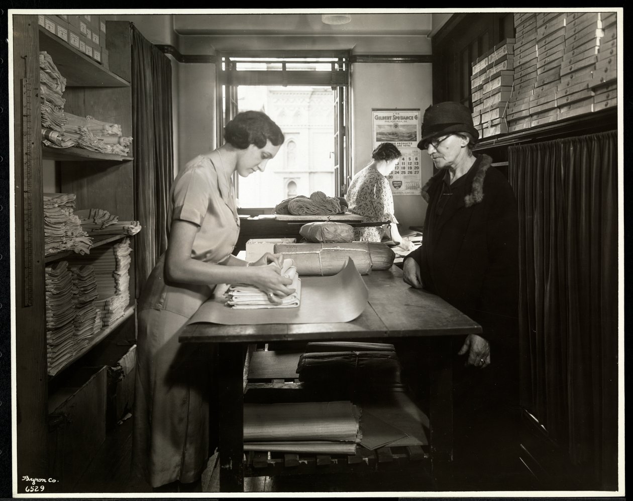Fiatal nő csomagol be anyagokat egy otthoni munkás számára, hogy magával vigye, a New York-i Vakok Egyesületénél, 111 East 59th Street, New York, 1931 (ezüstzselatinos nyomat). alkotó: Byron Company