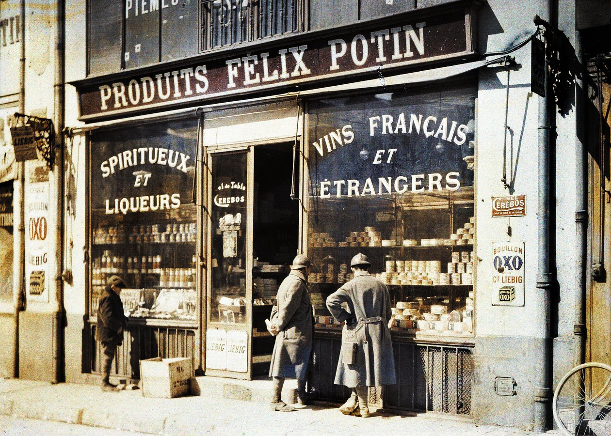 Két francia katona és egy fiú a Felix Potin italbolt előtt a piacon, Reims, Marne, Franciaország, 1917 (autokróm) alkotó: Fernand Cuville