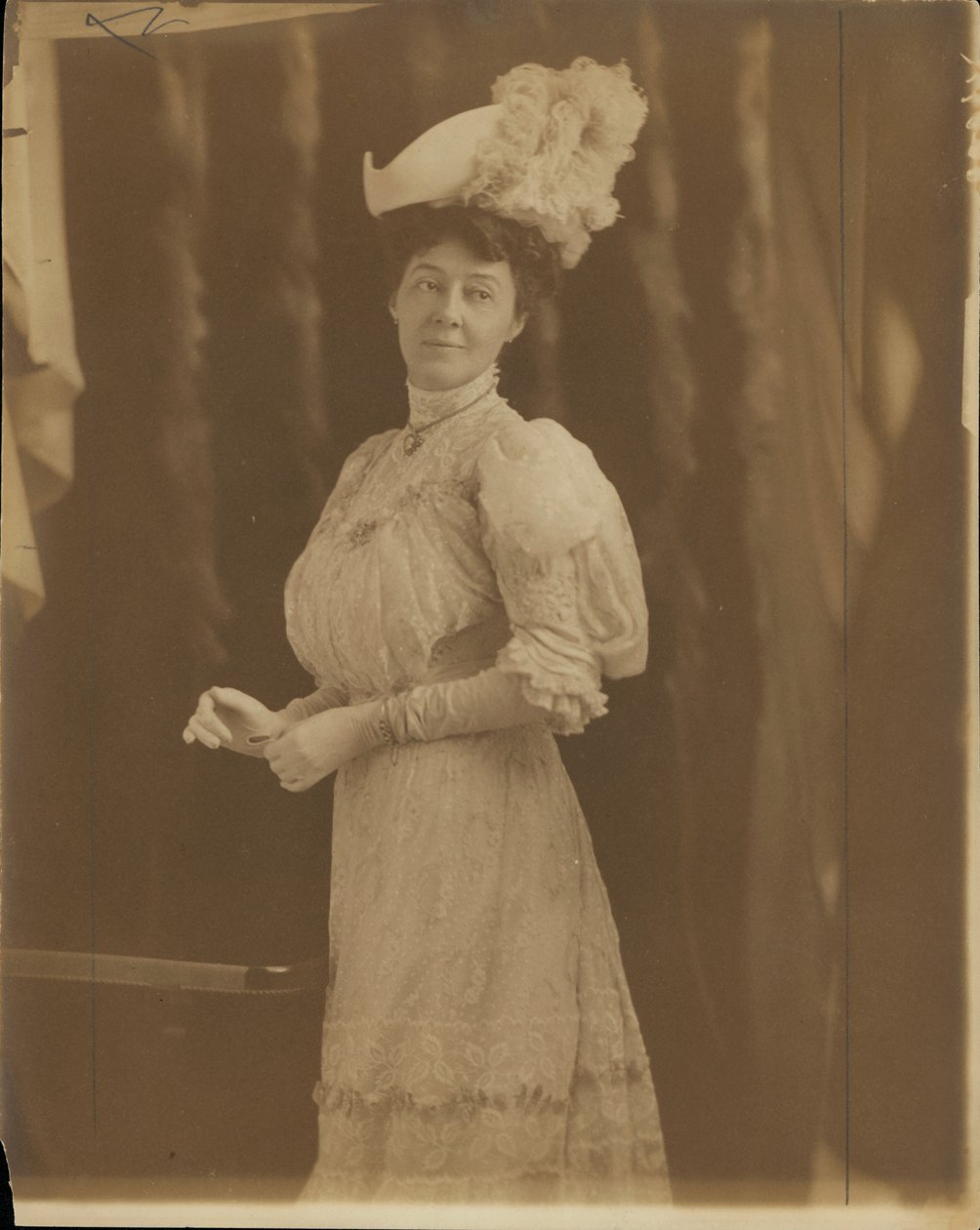 Mrs. Lon Stephens, született Margaret Nelson.  Magas nyakú csipkeruhát és tollas kalapot visel. alkotó: Unknown